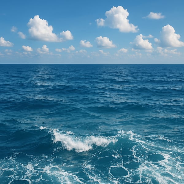 Scene of the ocean with a slight wave curl and a blue sky and light clouds